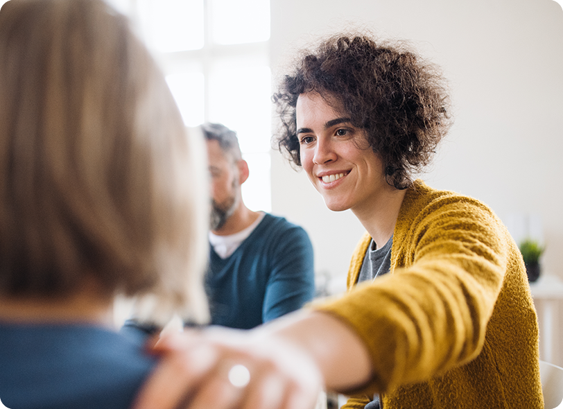 woman smiling with hand on persons shoulder