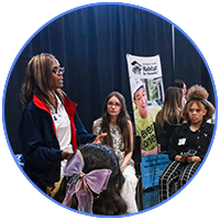 woman talking to seated kids