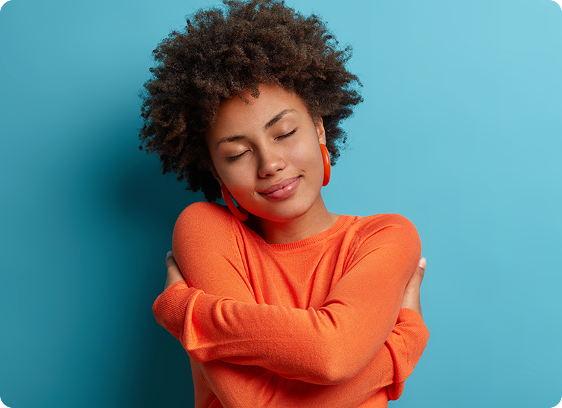 Smiling woman hugging herself