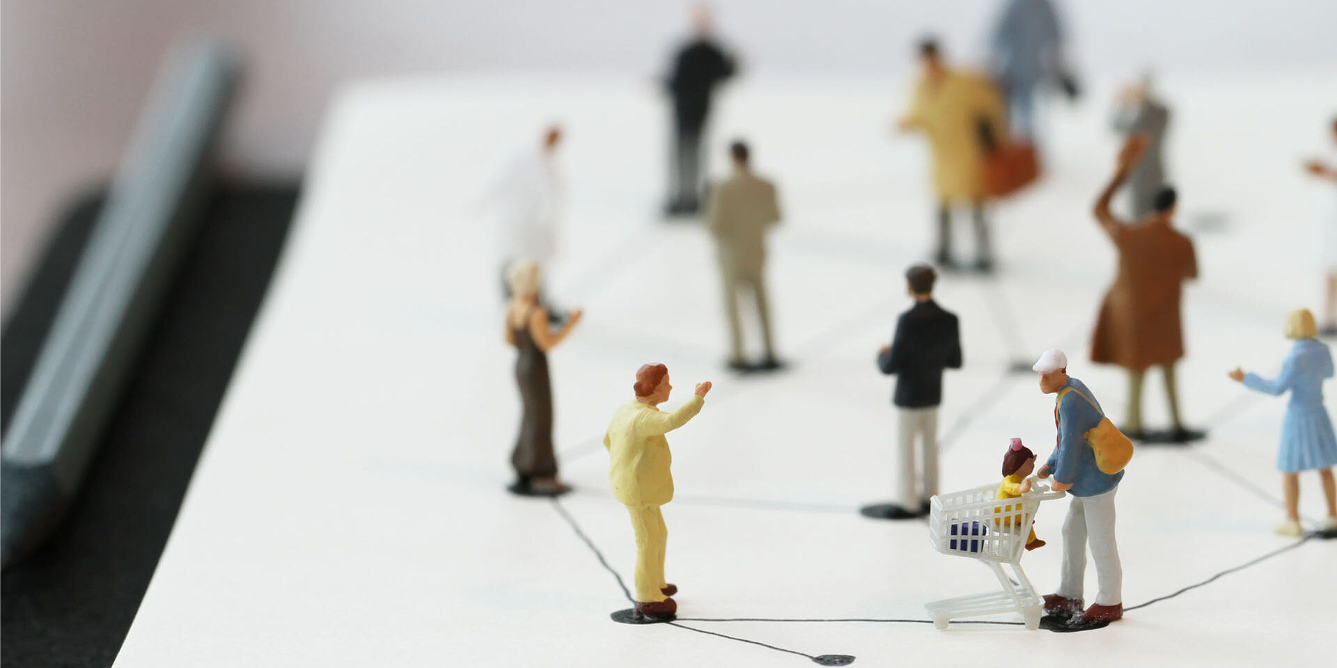close up of miniature people with social network diagram on open notebook on wooden desk as social media concept