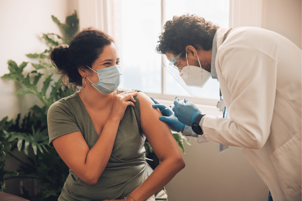 young woman with face mask on getting a shot